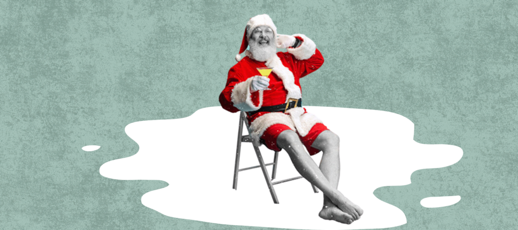 Santa in shorts, sitting on a chair enjoying a festive beverage.